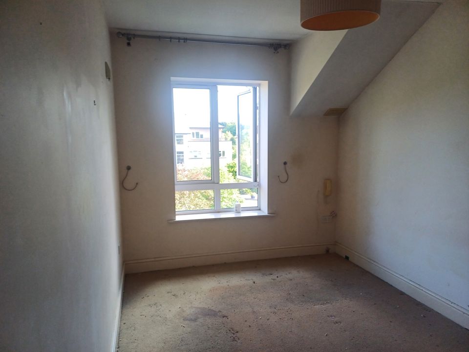 Completely empty apartment bedroom with bare marked carpet after contents were cleared out