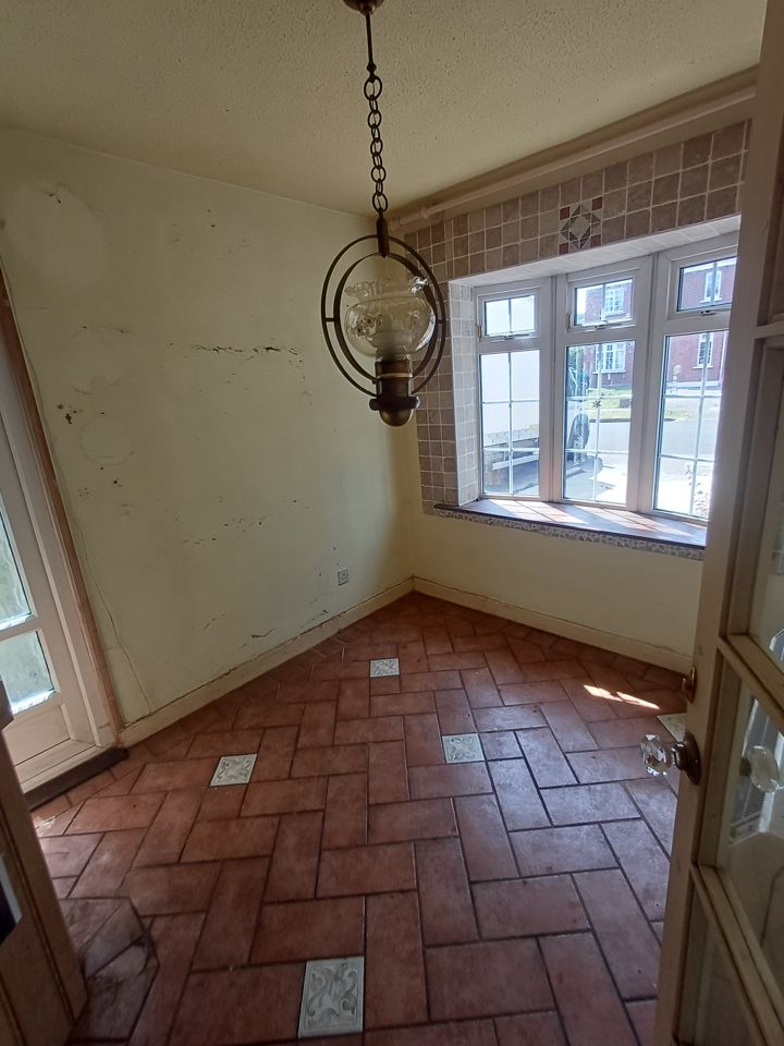 Emptied dining room with bay window and tiled floor; box van just visible parked outside