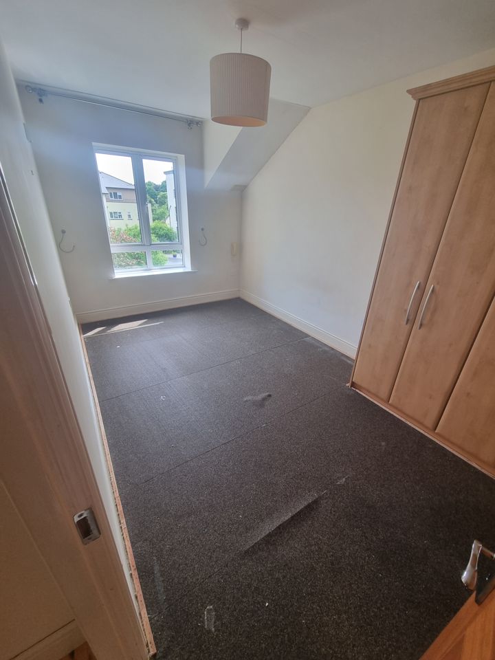 Apartment bedroom fully cleared with old carpet lifted, only fitted wardrobe remaining