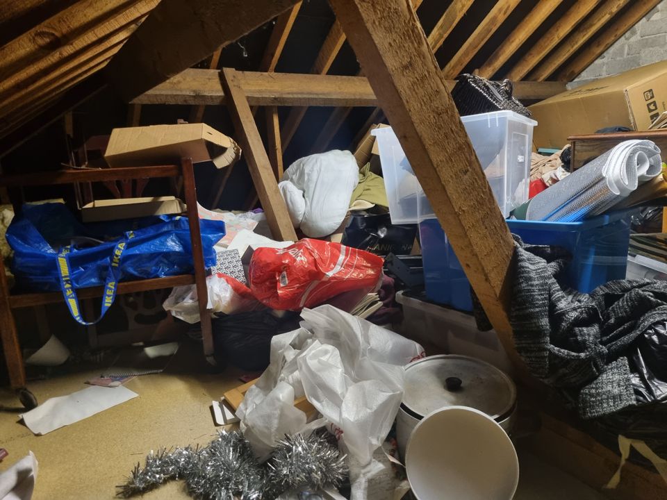 Attic crammed with bags, boxes and furniture before clearance
