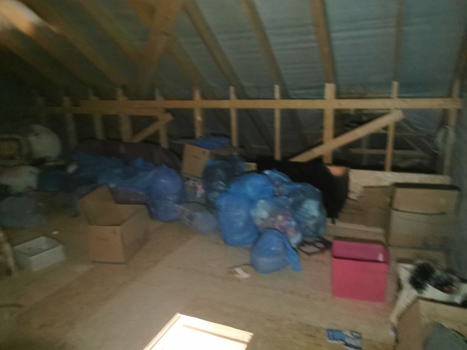 Bags and boxes stacked under the roof beams of a Dublin attic
