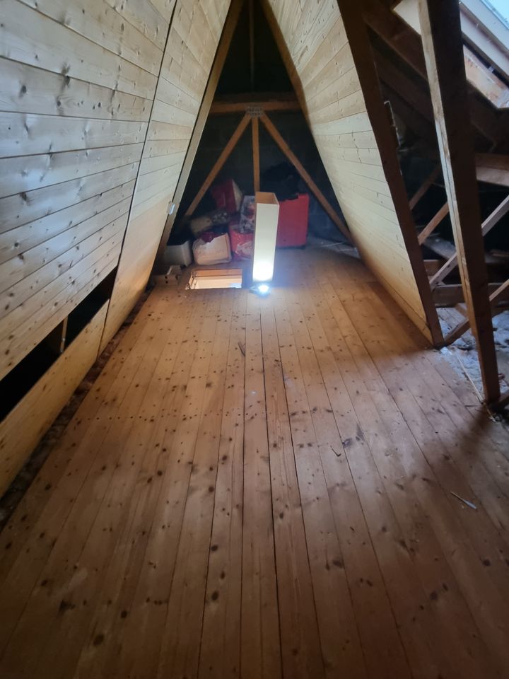 Timber-lined A-frame attic almost cleared, only a few bags left at the far end