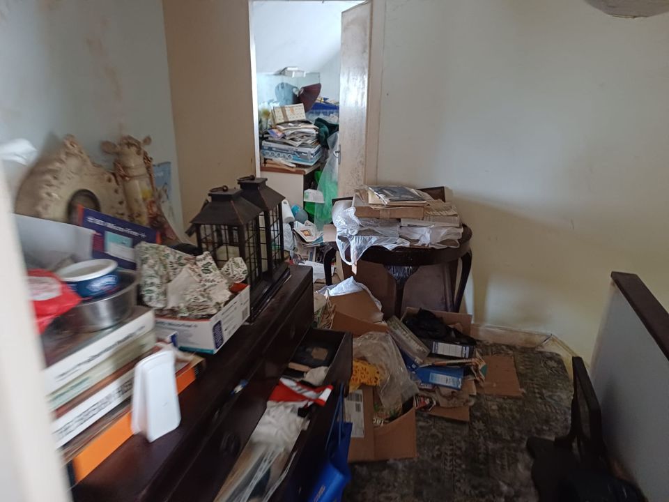 Cluttered hallway and furniture before a house clearance