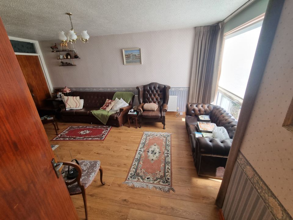 Fully furnished living room with leather Chesterfield suite, rugs and armchairs before house clearance