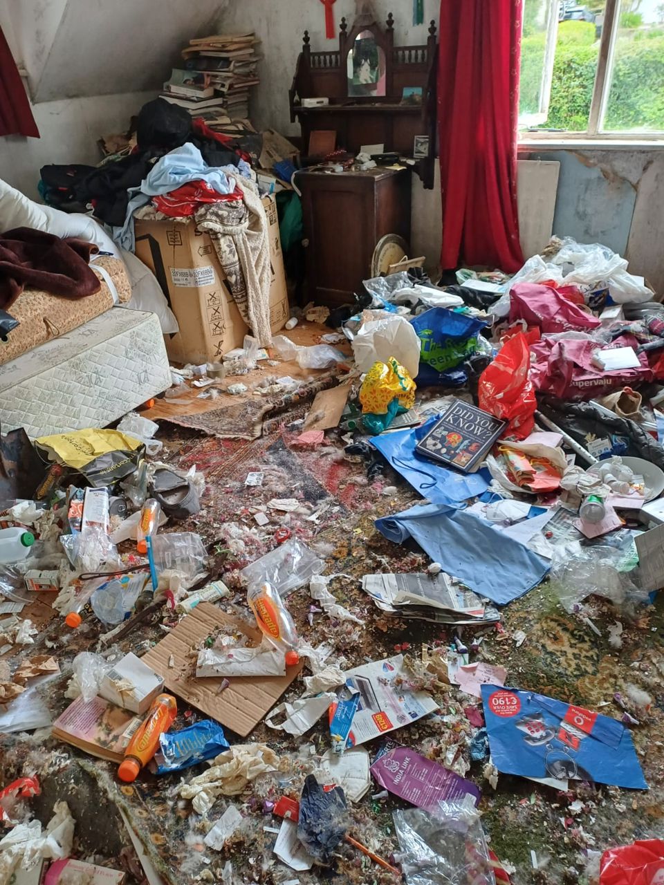 Heavily cluttered room before a hoarder clearance