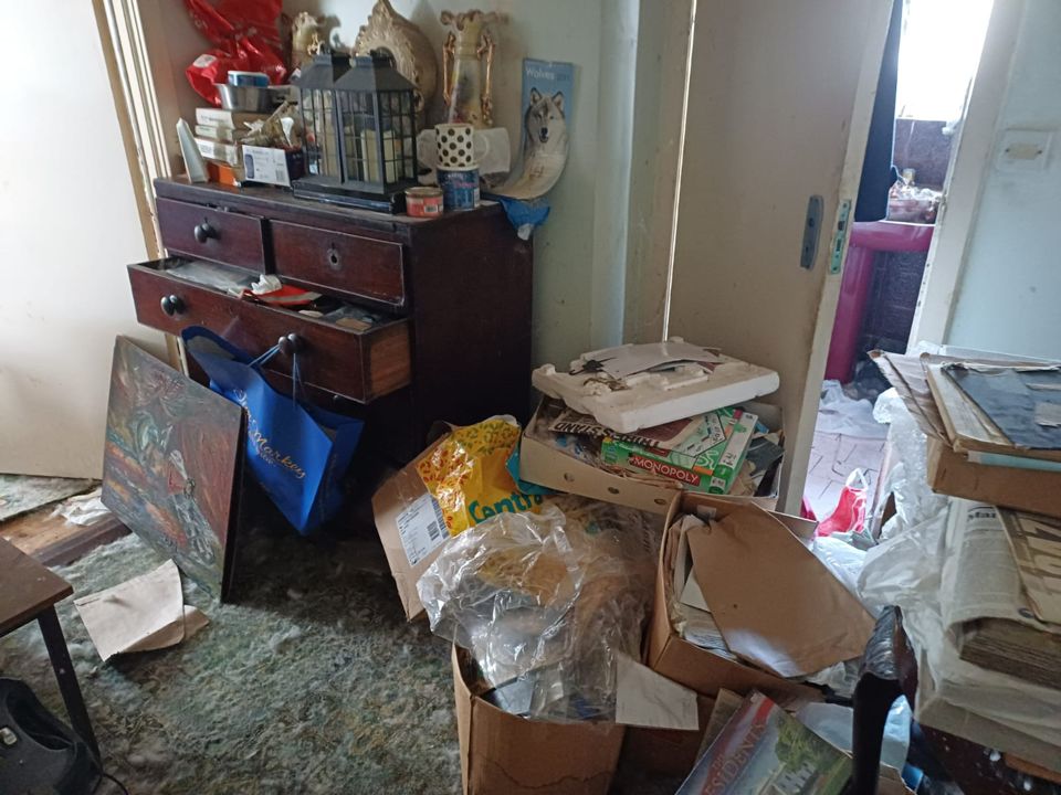 Room filled with boxes, papers and bags awaiting clearance