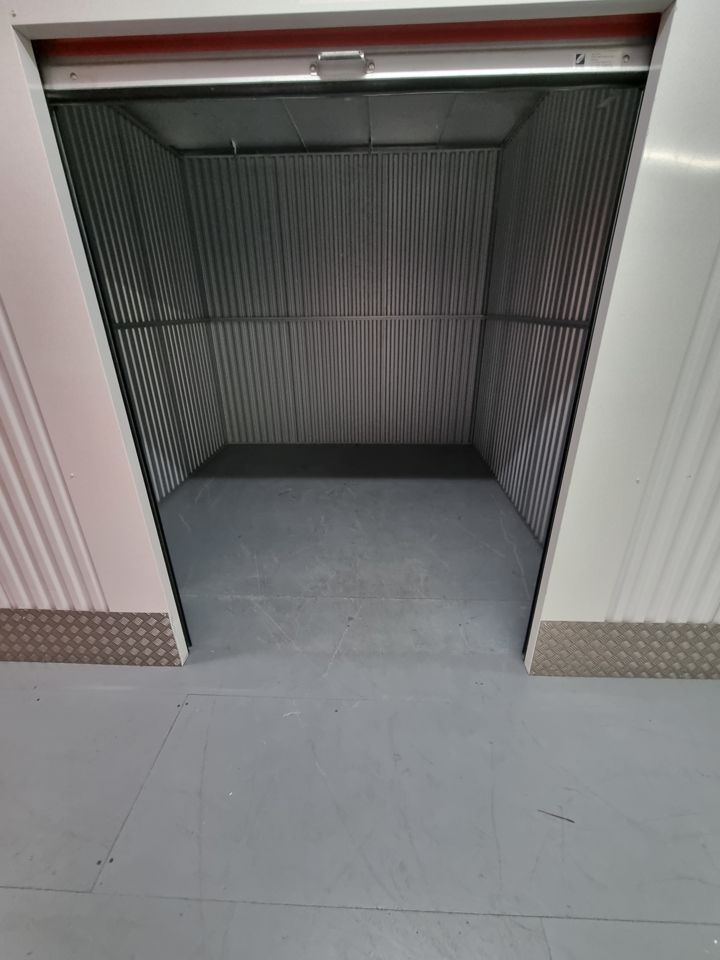 Empty self-storage unit with roller shutter raised after contents were cleared out