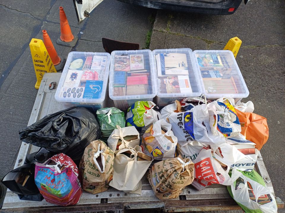 Van tail lift loaded with storage boxes of books and many bags of household contents