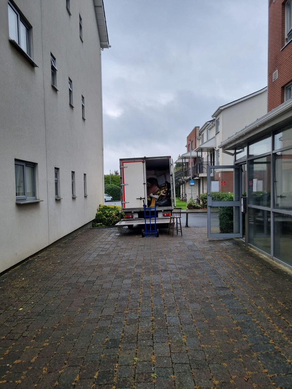 Our van loading furniture in the courtyard of a Dublin apartment block, sack truck at the tail-lift